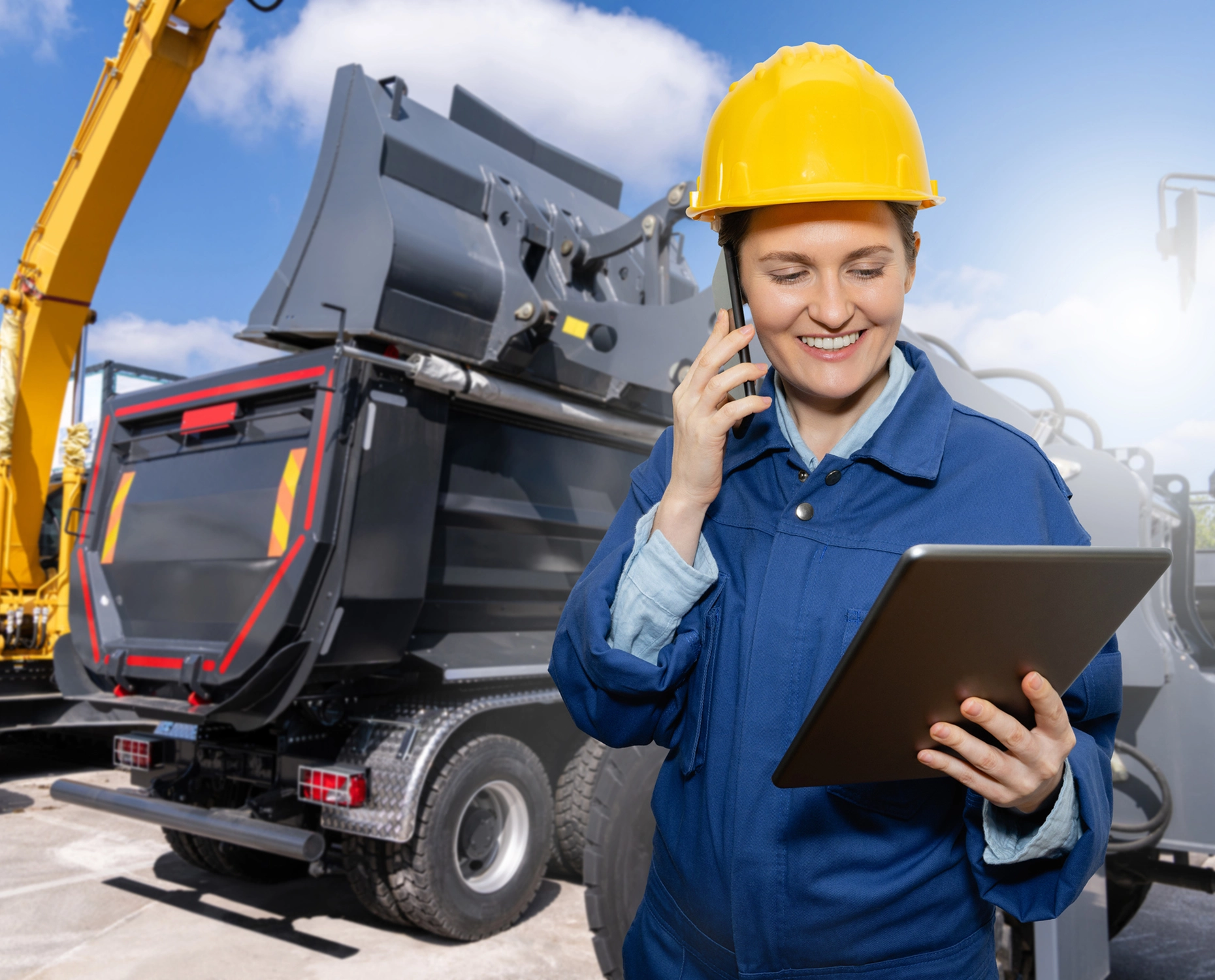 Construction worker with tablet and machinery.