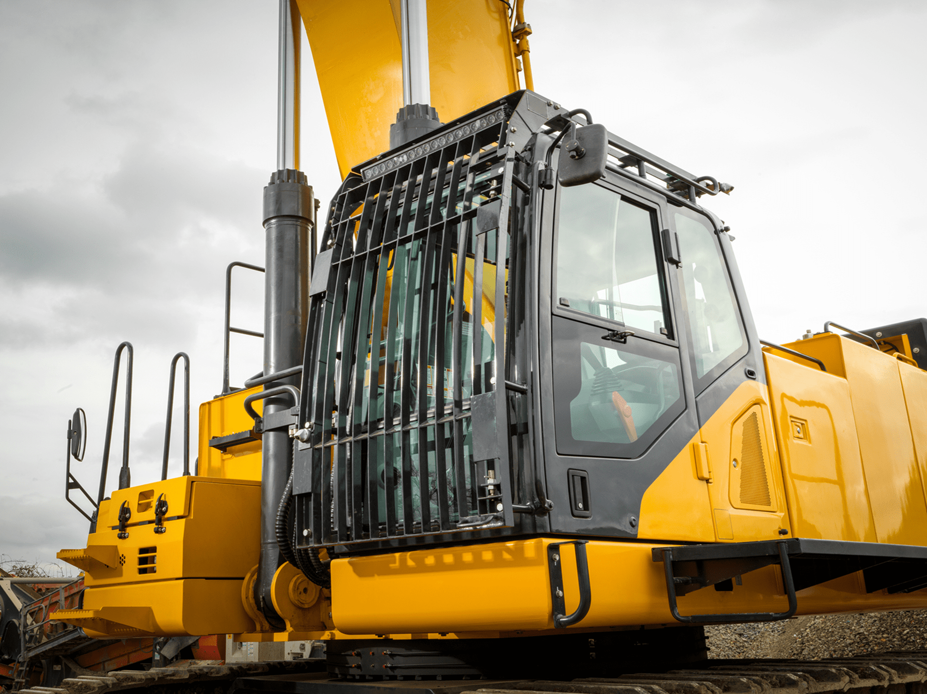 Yellow construction vehicle with protective cabin bars.