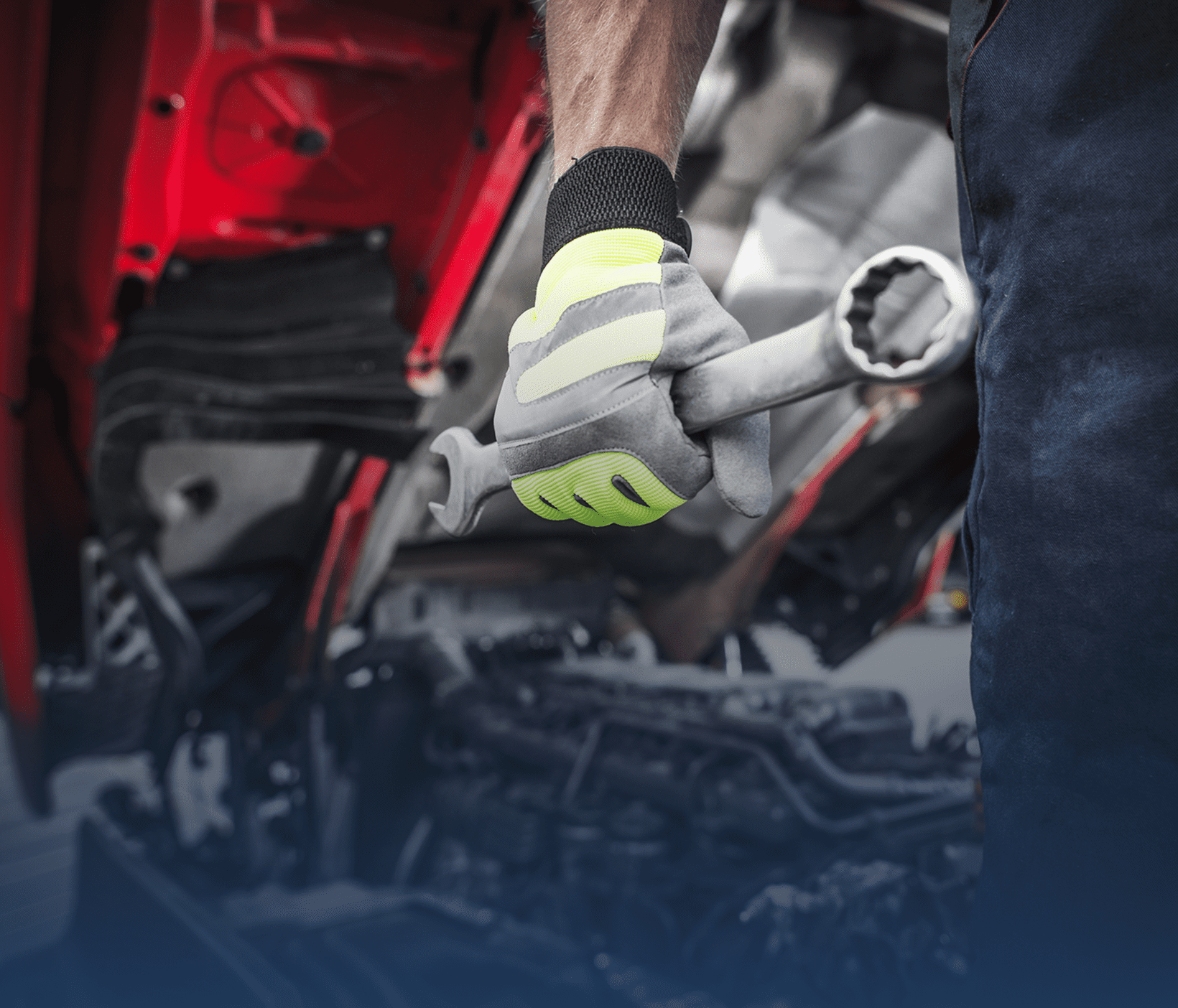 Mechanic wearing gloves working on vehicle engine components.