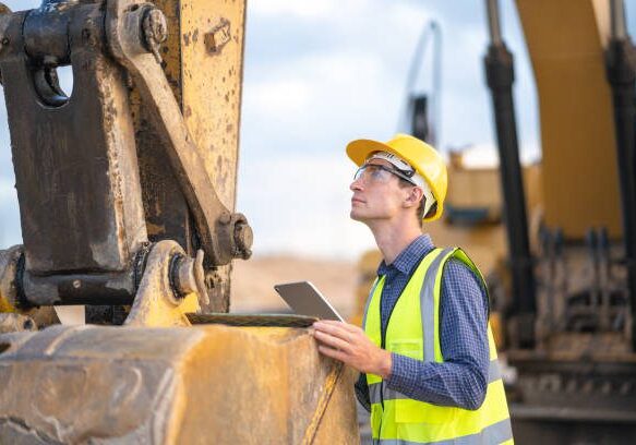 Male engineer service for soil excavation machine at construction site