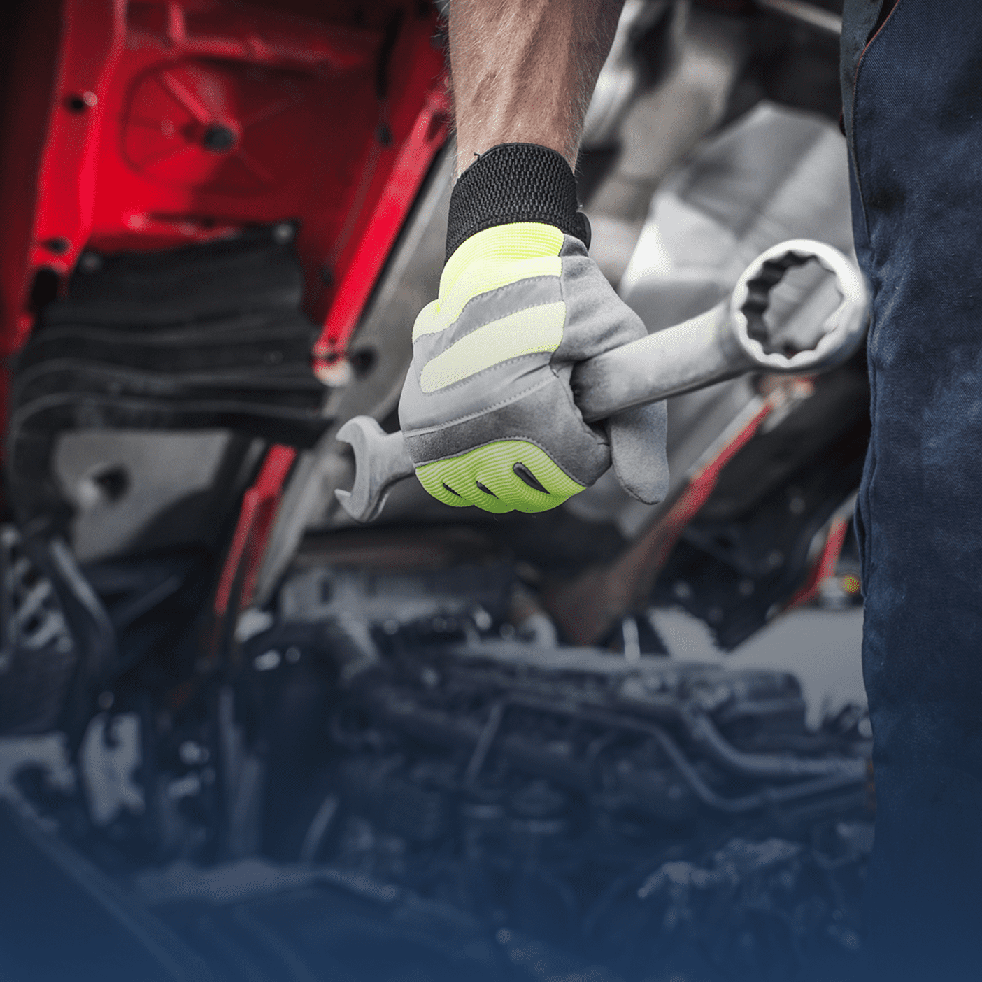 Mechanic wearing gloves working on vehicle engine components.